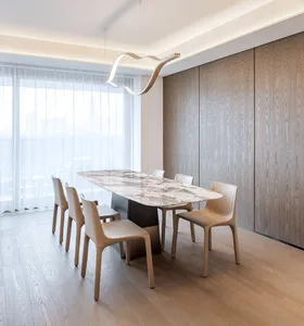 A modern dining room featuring a stone tabletop surrounded by minimalist chairs and a wooden ceiling with recessed lighting.
