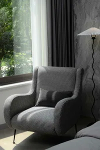 A modern living room featuring a black and white checkerboard armchair.