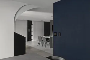 Modern minimalist dining room with concrete finishes featuring a sleek table and chairs.