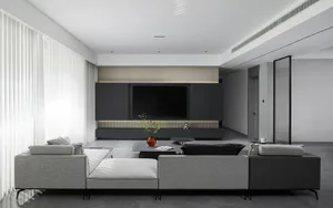 A modern minimalist living room featuring stone flooring, fabric furniture, and minimalist decor.