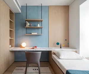 A minimalist bedroom with a marble desk, wooden shelves, and a single bed.