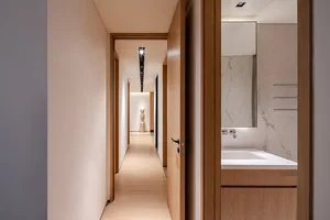 Modern minimalist bathroom featuring marble and wooden elements.