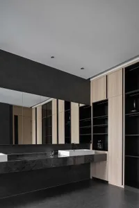 Modern minimalist bathroom featuring a concrete countertop and wooden cabinets.