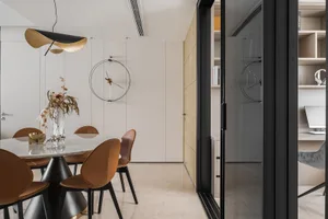 Modern dining room featuring a marble dining table with concrete legs, leather chairs, and a metal pendant light.