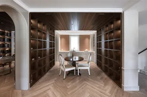 A modern library with wooden shelves, white chairs, and a small dining area.