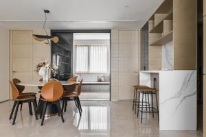 A modern kitchen interior with a marble countertop and wooden flooring.