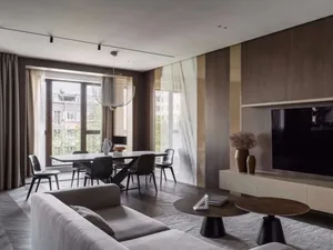 A modern minimalist living room with a white sofa, marble coffee table, and dark wood flooring.