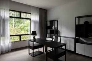 A modern office space with wooden furniture and a large window.