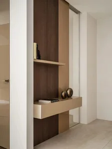 A minimalist, modern entryway featuring integrated storage and a floating console with metallic accents.