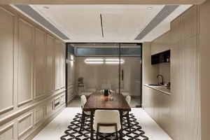 Modern kitchen and dining area with wooden dining table and marble finishes.