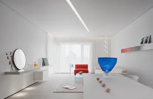 A minimalist living room featuring a glass table illuminated by blue lighting, with blinds allowing natural light in.