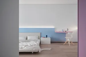 A modern minimalist bedroom with white bedding, a floating desk, and a simple design aesthetic.