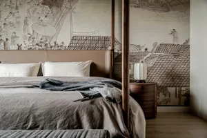 A modern bedroom featuring a fabric mural with intricate designs and a four-poster bed.