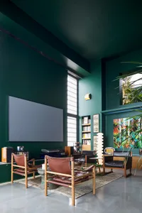 A modern living room featuring leather furniture, concrete flooring, and glass elements.