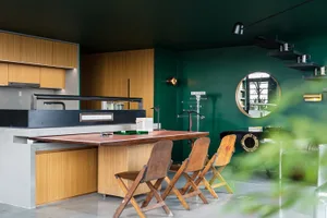A modern kitchen with industrial design features including wooden furniture, concrete countertops, and metal accents.
