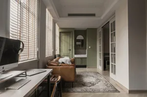 A modern living room featuring a wooden desk, a leather sofa, and textured decorations.