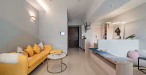 A modern minimalist living room with a yellow sofa and a white coffee table.