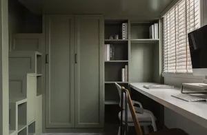 A minimalist study or home office featuring green walls, a white desk, and a window with blinds.
