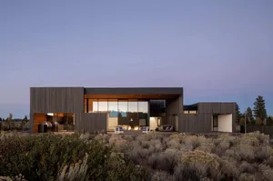 Modern residential exterior with wooden siding and large glass windows