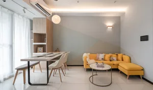 A modern living room with a yellow sofa, wooden floor, and glass coffee table.