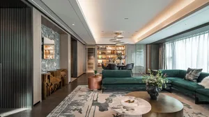 Modern living room featuring a green sofa, metallic coffee table, and decorative lighting.