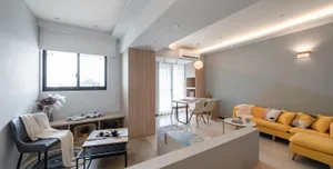Modern minimalist living room with wooden furniture, leather accents, and textiles