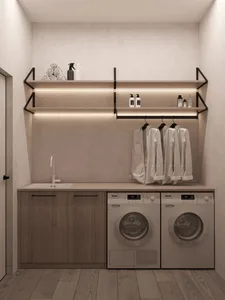 Modern laundry room with wood cabinets, shelves, and washing machines.
