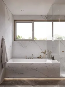 Modern bathroom with marble walls and floor, featuring a bathtub and window.