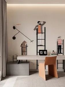 A minimalist office space featuring a modern desk with a laptop, a beige chair, and decorative wall art depicting film strips