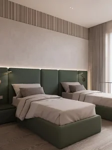 A modern minimalist bedroom with twin beds upholstered in green fabric, white bedding, and wall-mounted lamps.