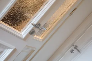 Close-up view of elegant glass cabinet doors featuring textured glass inserts.