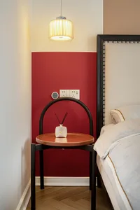 A modern bedroom featuring a red accent wall.