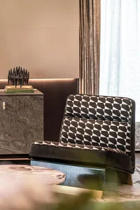 A modern interior design featuring a patterned leather chair, a textured wooden cabinet, and a round table.