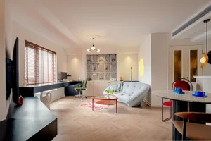 A modern living room featuring a mix of materials such as wood, glass, and fabric with a contemporary sofa, coffee table, and