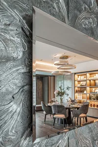 Modern dining room featuring a textured metallic wall and elegant dining table.