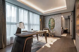 A modern home office featuring a wooden desk, leather chair, and luxurious interior design elements.