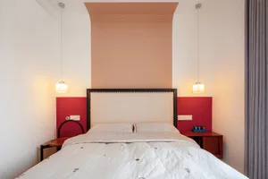A modern bedroom with a white bed and fabric headboard.