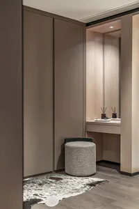 A minimalist dressing room featuring modern furnishings and a dressing table.