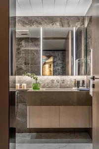A modern bathroom featuring marble surfaces and a floating vanity.
