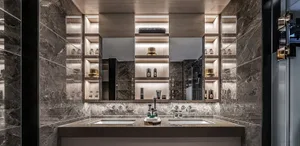 Modern luxury bathroom featuring marble walls and countertops with a double sink and illuminated shelves.