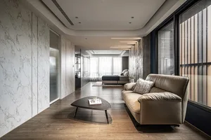 Modern living room featuring a white marble wall and floor, with a beige leather sofa and a contemporary coffee table.