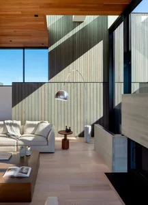 Modern minimalist living room with wooden elements and a floor lamp.