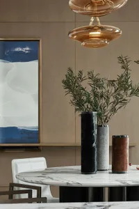 現代餐廳，擺放大理石餐桌、黑灰色花瓶與抽象牆面藝術作品。