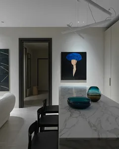 A modern, minimalist kitchen interior featuring a marble counter top with two glass bowls.
