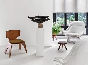 A minimalist living room featuring a sculpture on a white pedestal.