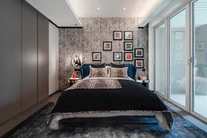Modern bedroom with a bed featuring leather upholstery, metal headboard, and glass nightstands.