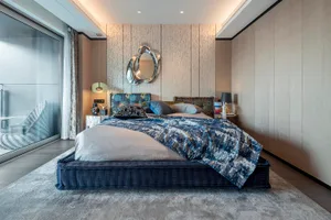 Modern bedroom with fabric furniture, minimalist design, and a combination of dark and light tones.