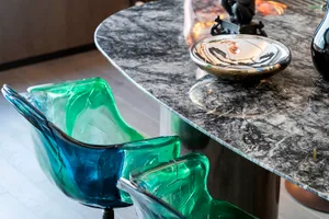 Modern interior design featuring glass chairs and a marble table.