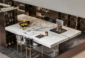 A luxurious kitchen bar featuring a marble countertop, a bowl of lemons and cherries, and a tray with bottles of alcohol.
