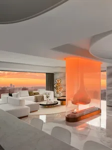 Modern living room featuring marble flooring and furniture, with a firepit and panoramic city view at sunset.